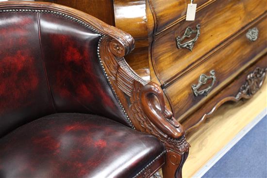 A pair of French Empire style carved mahogany and brass studded leather tub shaped armchairs,